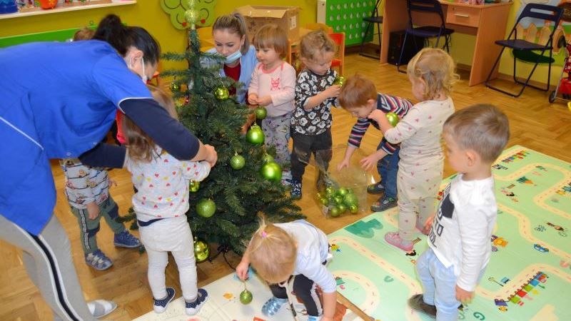 Dzieci ubierają choinkę na święta