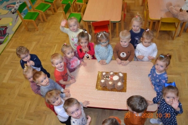 Dzieci wokół tortu w kształcie misia